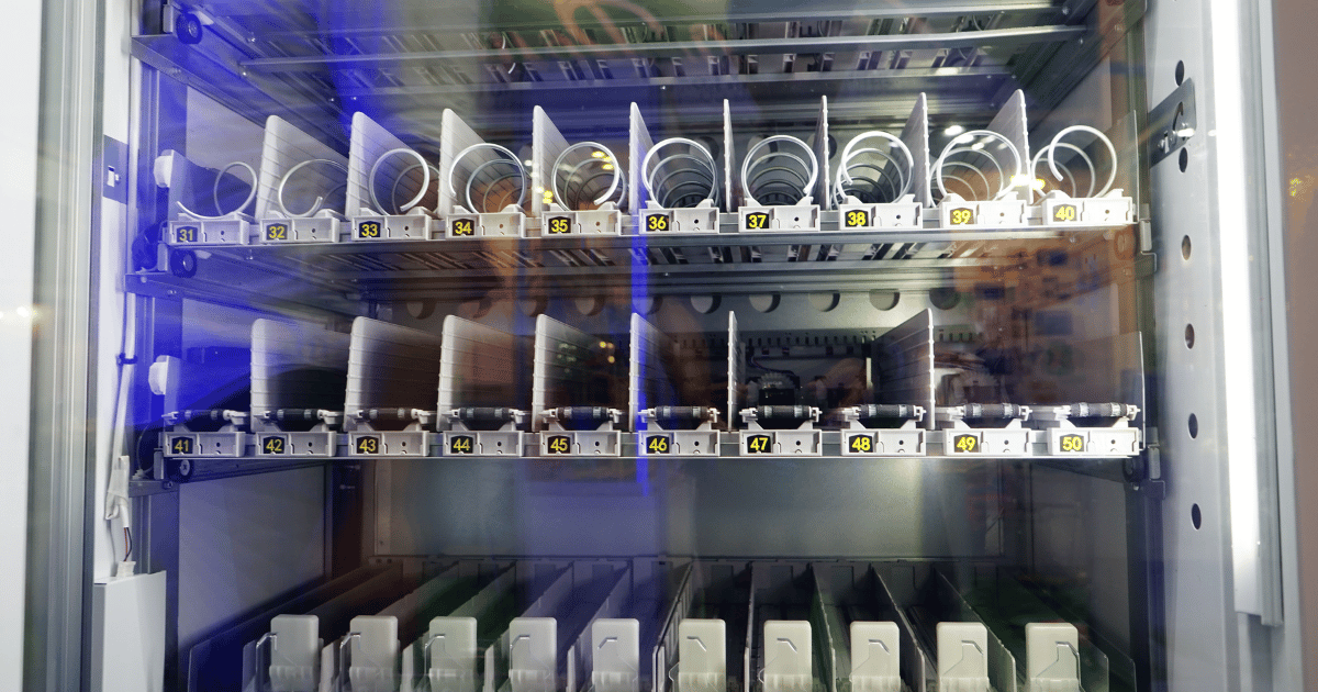 Empty vending machine shelves needing to be filled with snacks.